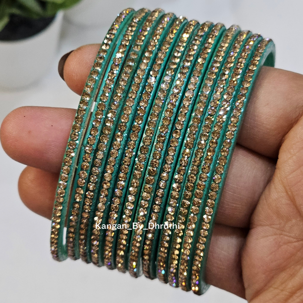 Teal and gold bangles on a hand with a blurred background Light Blue Colour Amulya Stone Glass Bangles